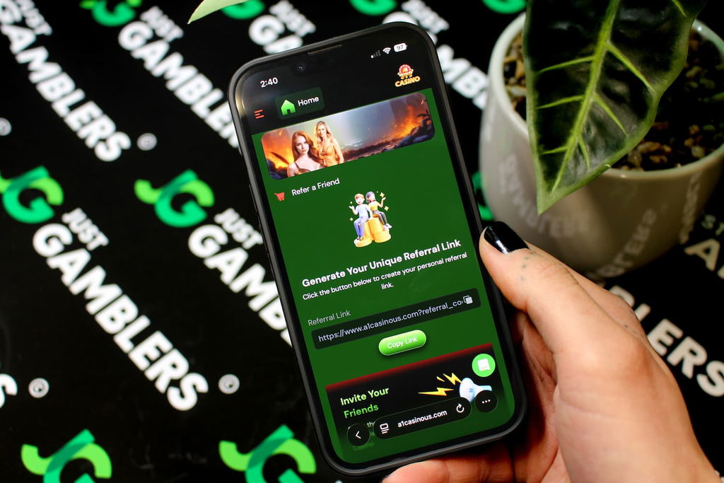 Angela Zillich holding an iPhone with the A1 casino refer-a-friend page loaded on the webpage.