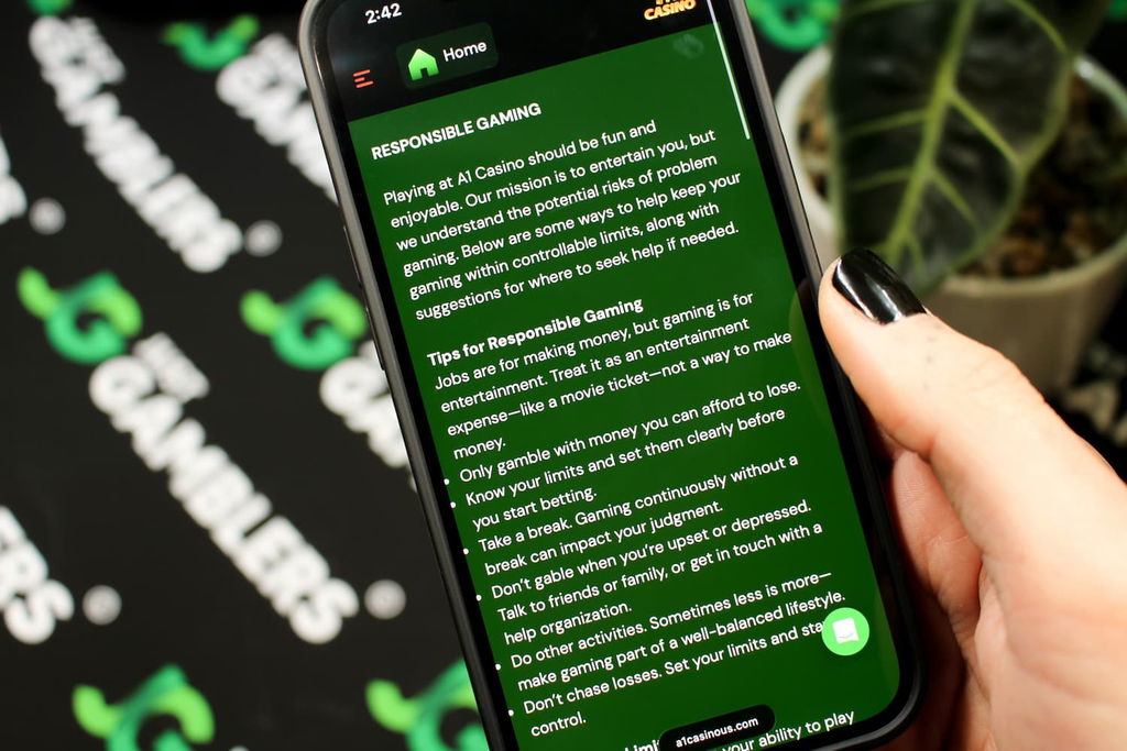 Angela Zillich holding an iPhone with the A1 casino Responsible Gaming page loaded on the webpage.