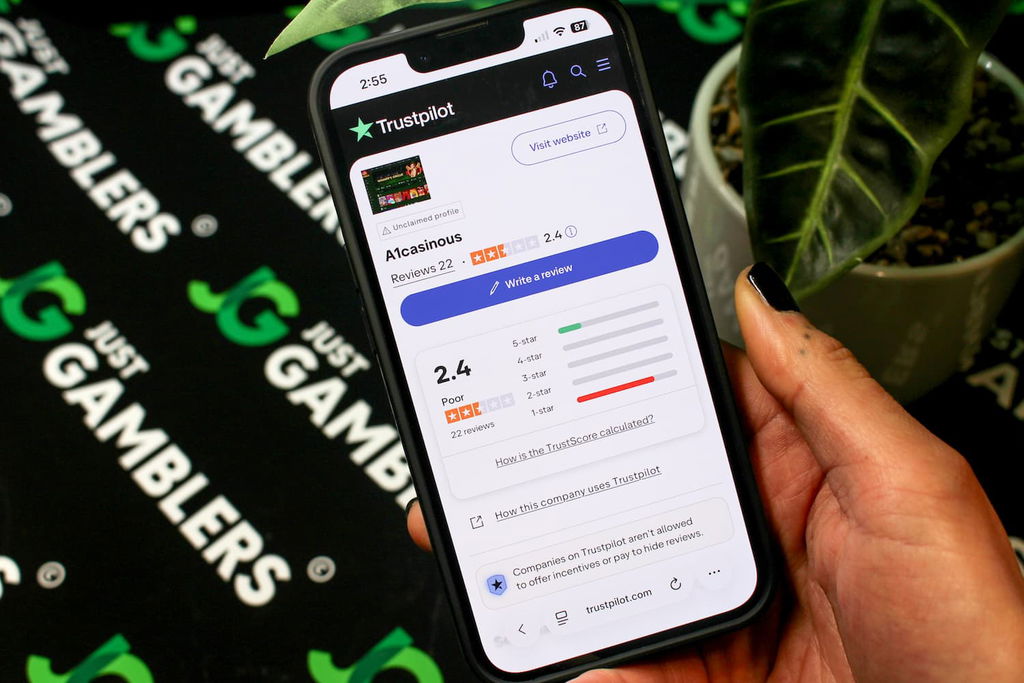 Angela Zillich holding an iPhone with the A1 casino Trustpilot page loaded on the webpage.