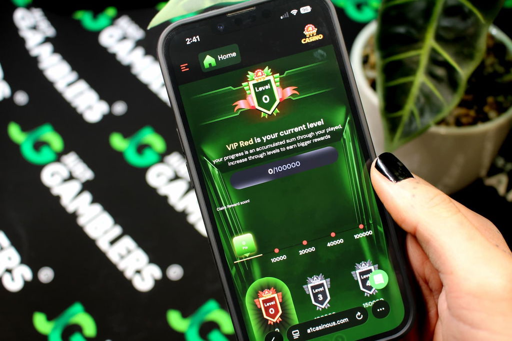 Angela Zillich holding an iPhone with the A1 casino VIP Program page loaded on the webpage.