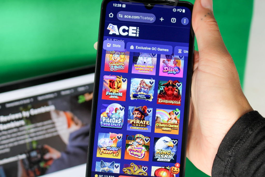 Angela Zillich holding an iPhone with the Ace casino gaming lobby page loaded on the webpage.
