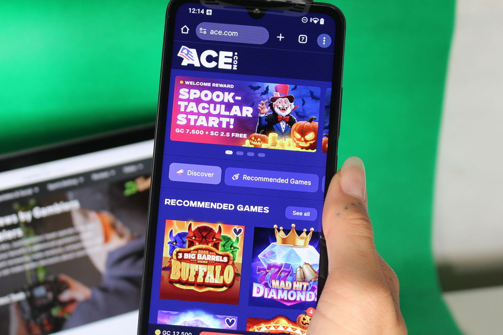 Angela Zillich holding an iPhone with the Ace casino landing page loaded on the webpage.