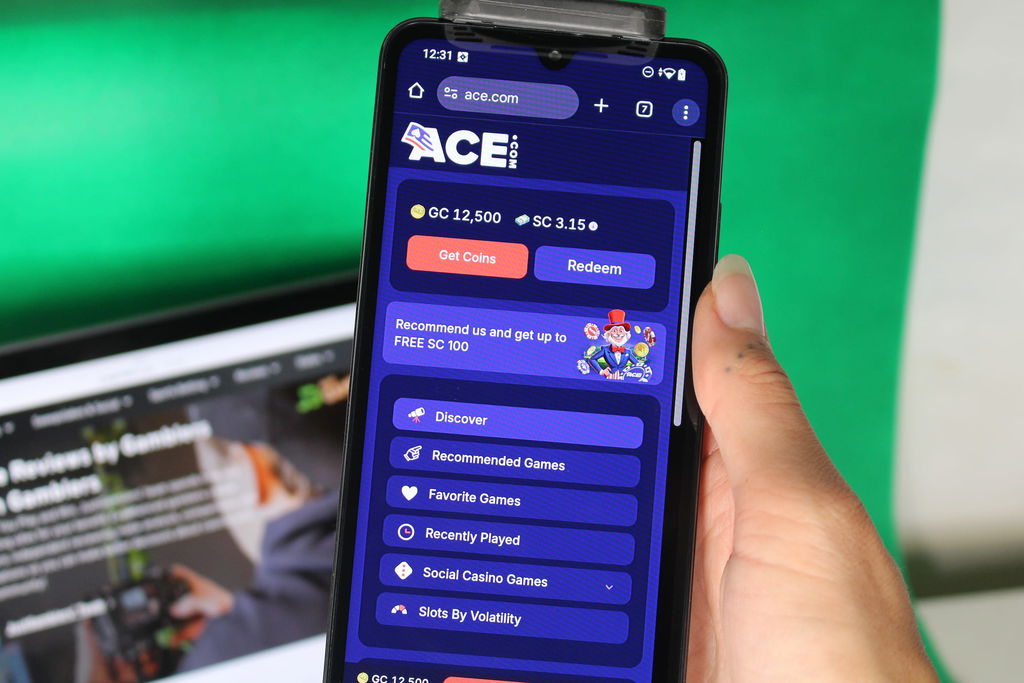 Angela Zillich holding an iPhone with the Ace casino menu page loaded on the webpage.