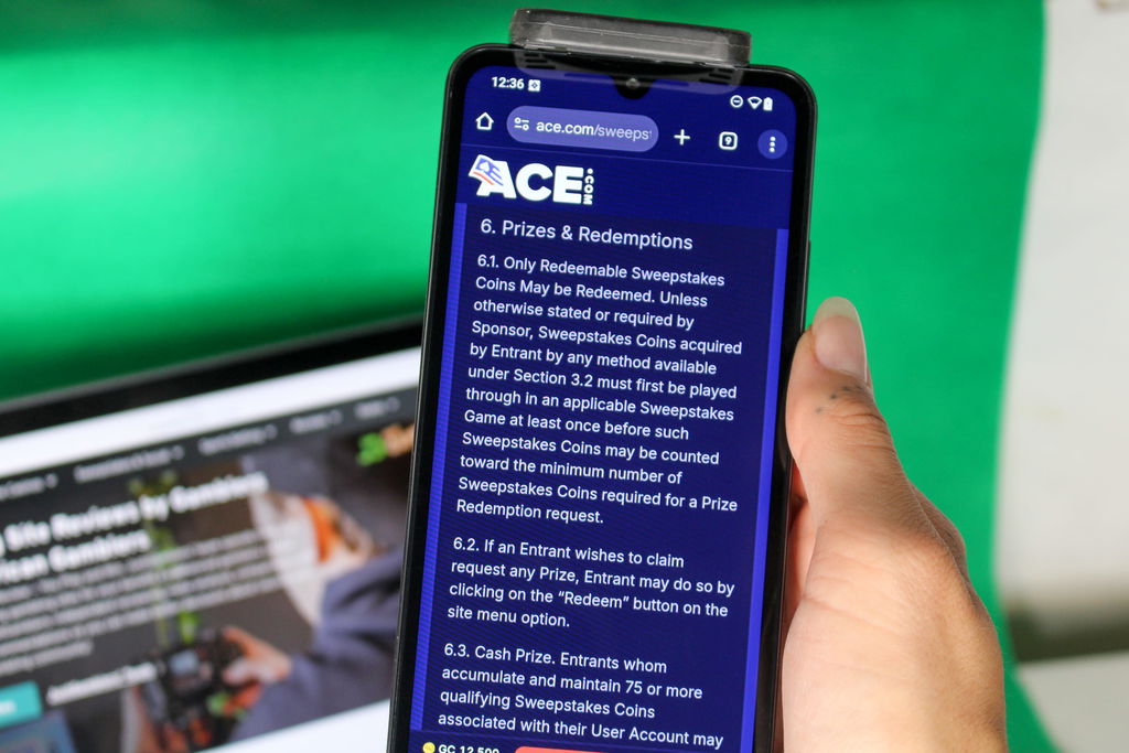 Angela Zillich holding an iPhone with the Ace casino redemptions page loaded on the webpage.