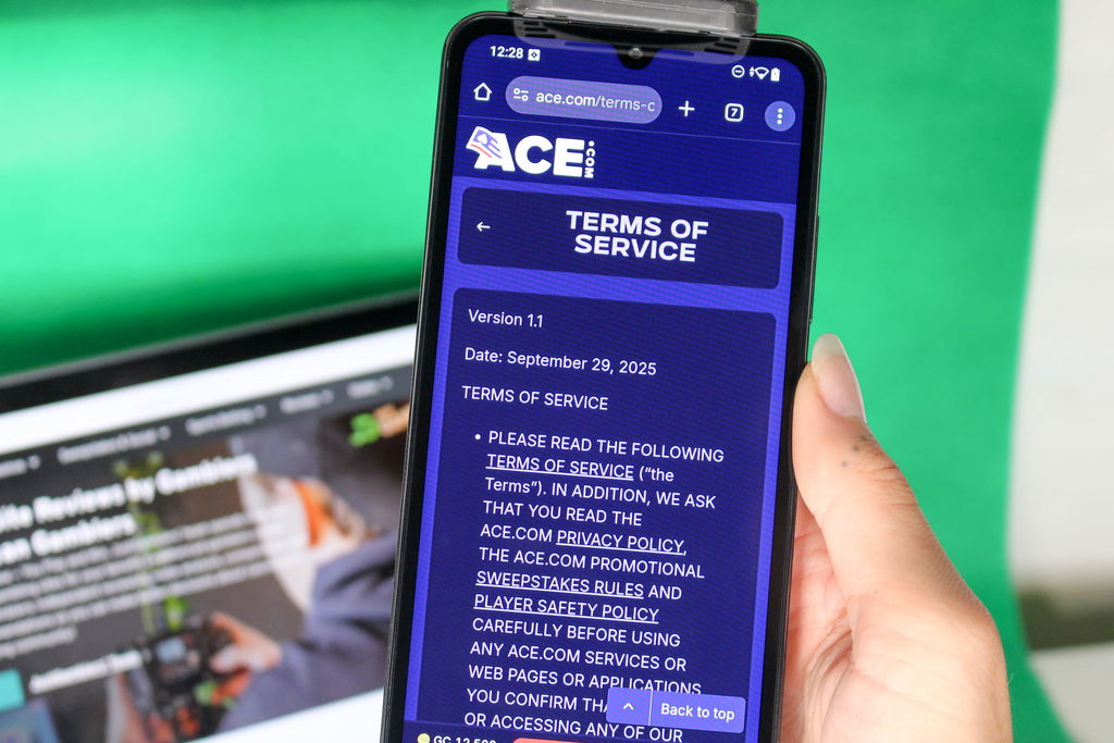 Angela Zillich holding an iPhone with the Ace casino Terms and Services page loaded on the webpage.