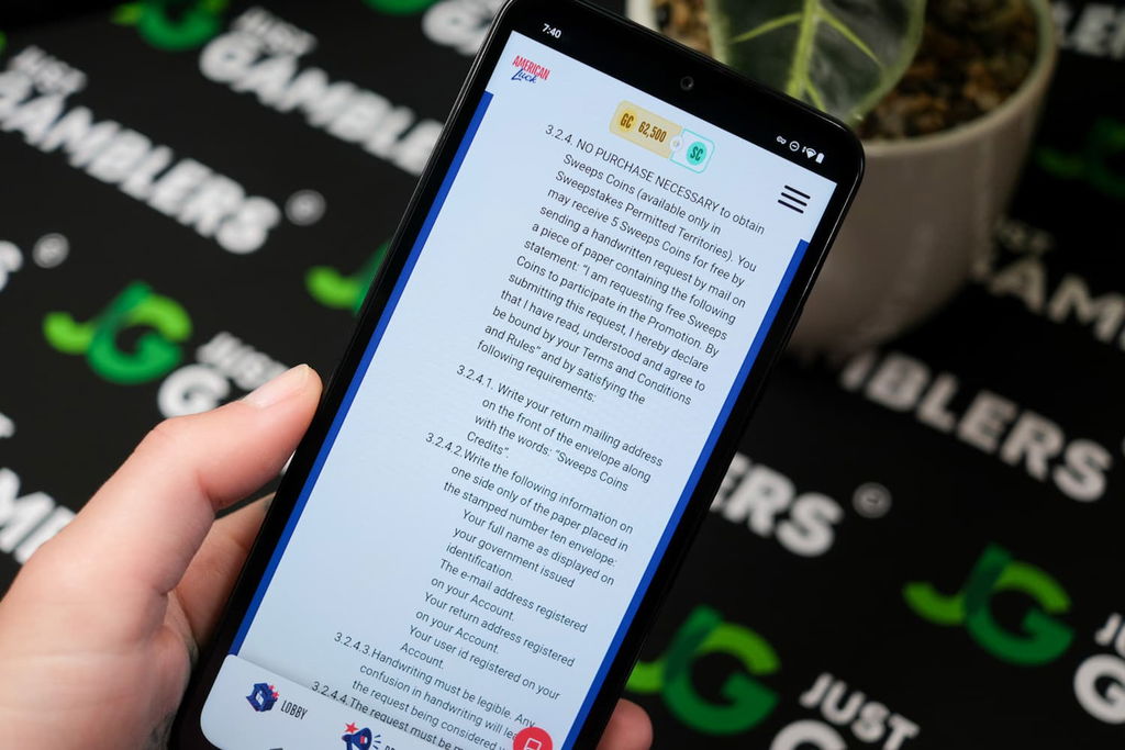 Angela Zillich holding an Android Phone with the American Luck casino AMOE page loaded on the webpage.