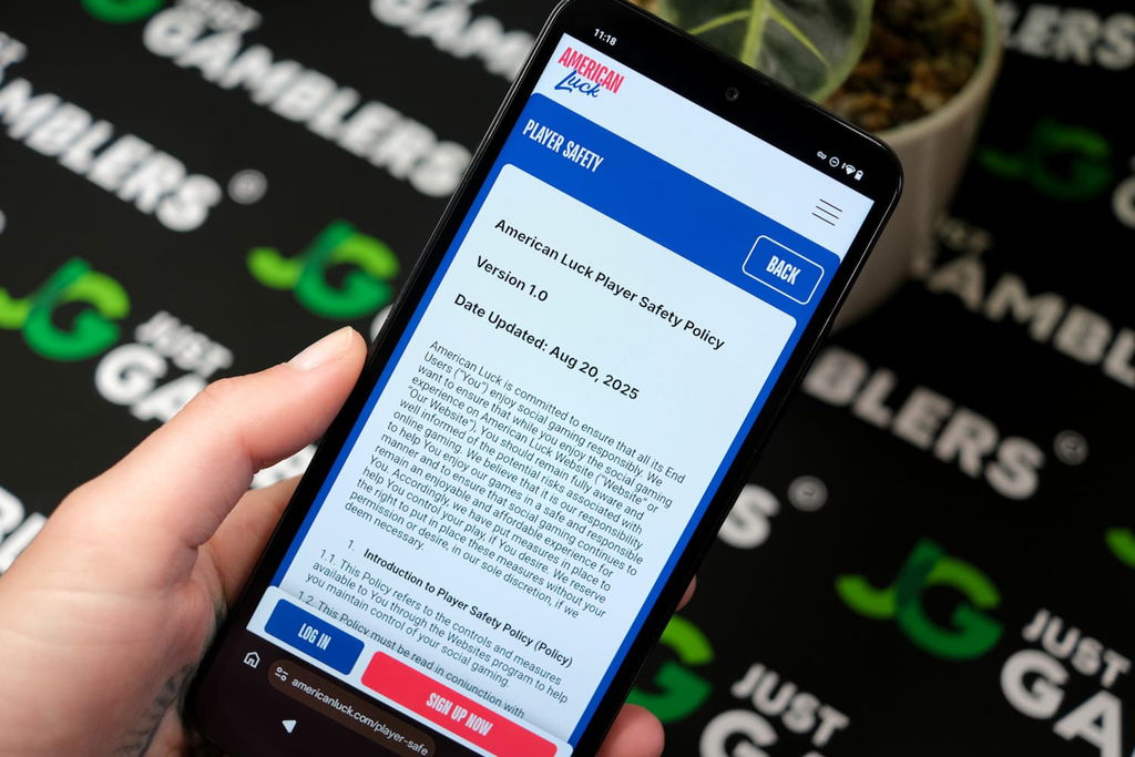 Angela Zillich holding an Android Phone with the American Luck casino responsible gaming page loaded on the webpage.