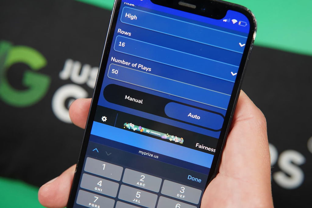 Photo of Patrik Lidin holding an iPhone showing the Autoplay option in Plinko.