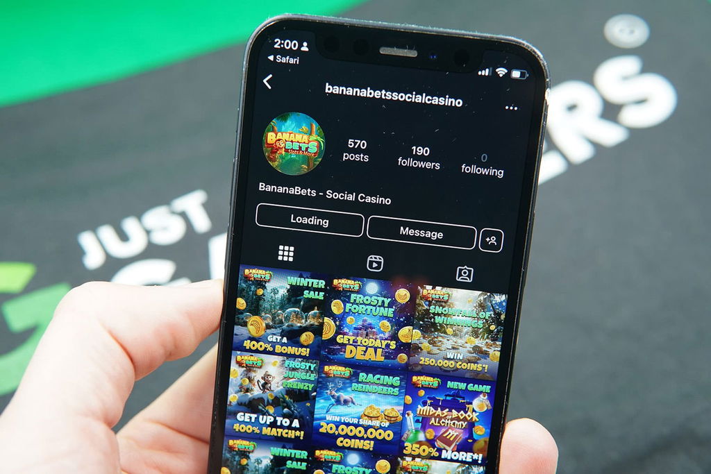 Patrik Lidin holding an iPhone with the McLuck casino loaded on the webpage.