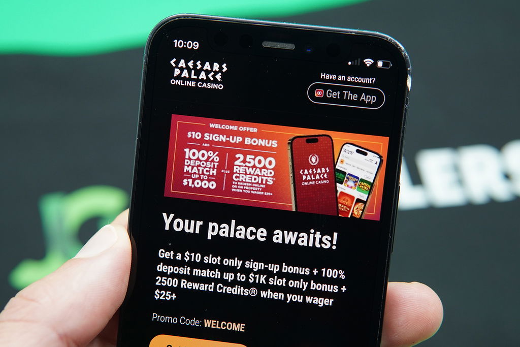 Photo of Patrik Lidin holding the Caesars Palace site with a no deposit bonus showing.