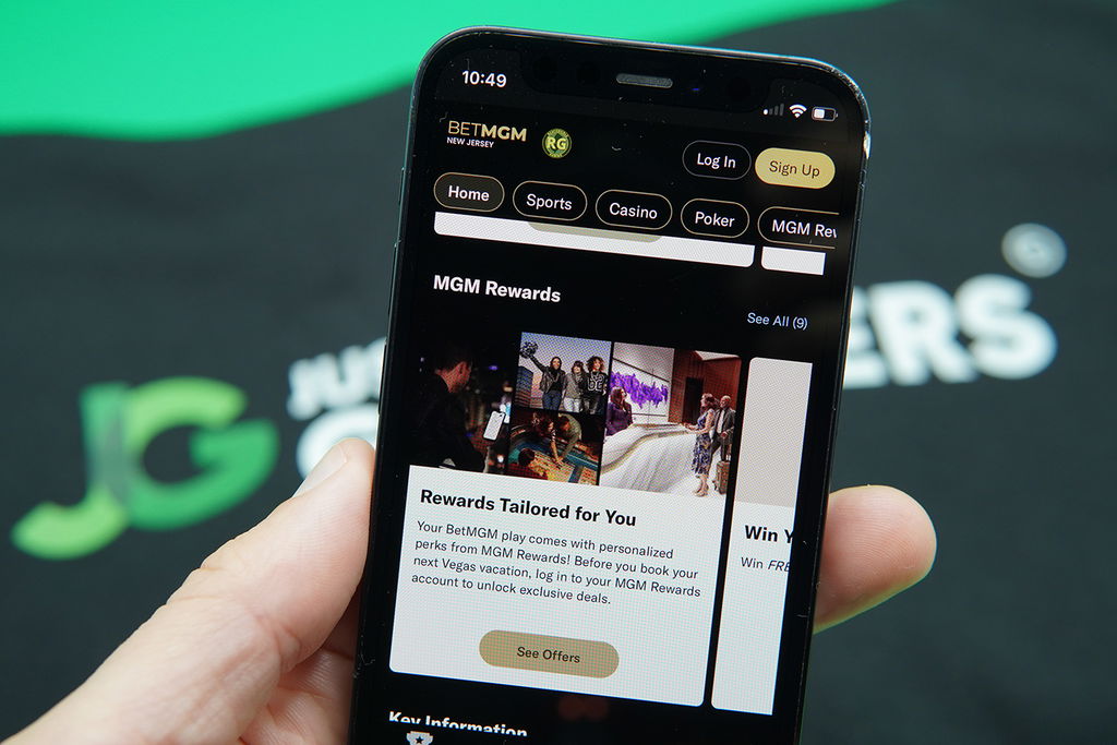 Photo of Patrik Lidin holding an iPhone with the BetMGM loyalty program loaded.