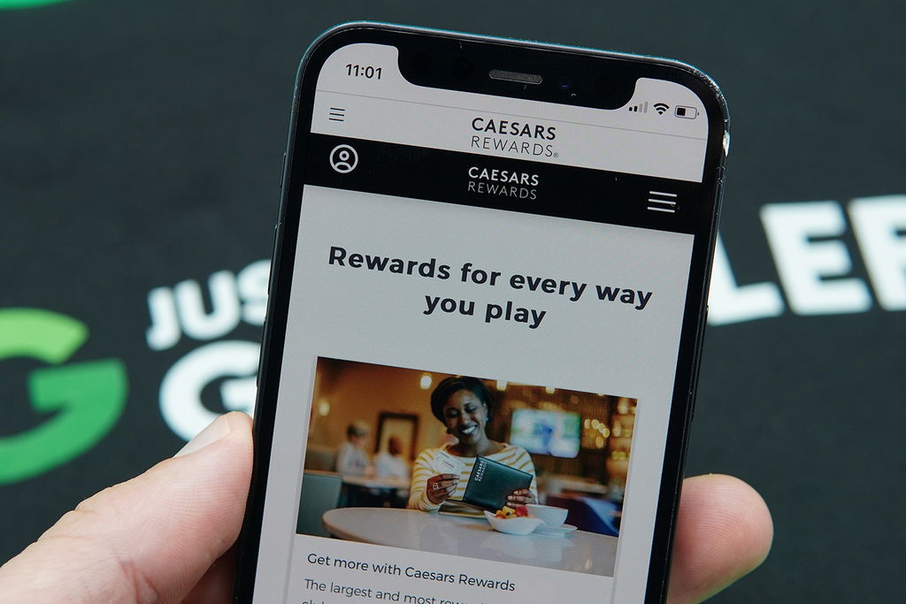 Photo of Patrik Lidin holding an iPhone with the Caesars Rewards loyalty program loaded.