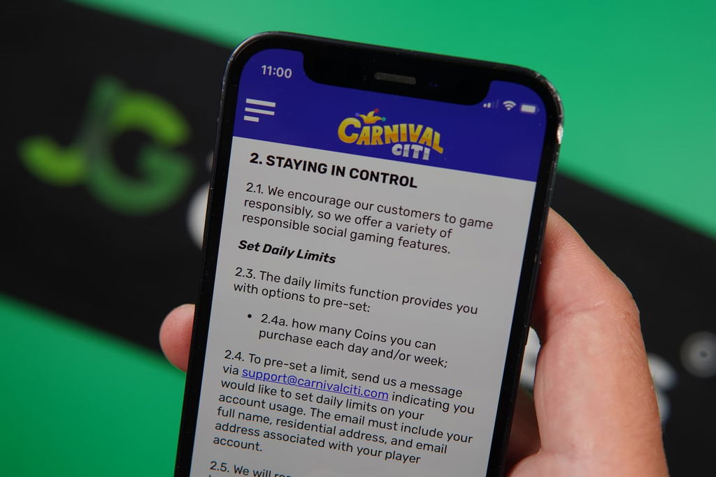 Patrik Lidin holding an iPhone with the Carnival Citi casino Responsible Gaming page loaded on the webpage.