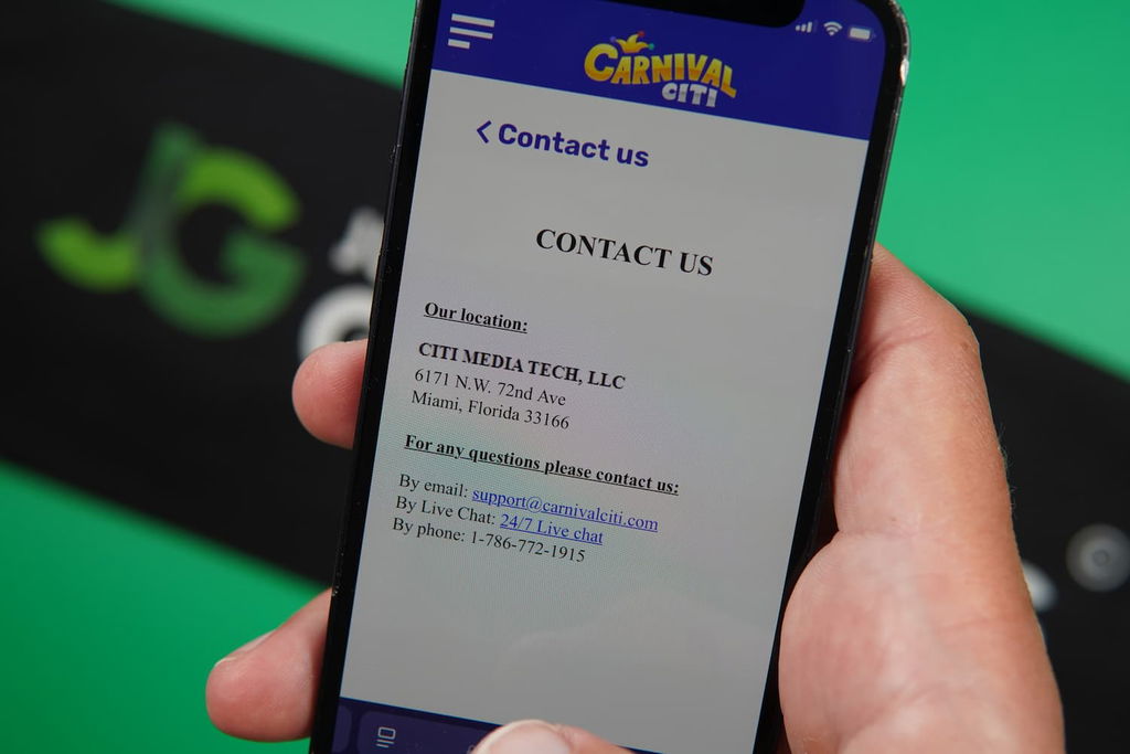 Patrik Lidin holding an iPhone with the Carnival Citi casino support page loaded on the webpage.