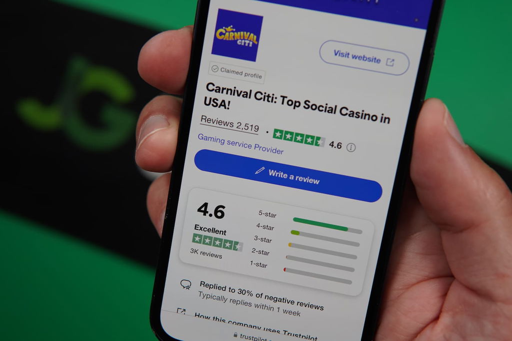 Patrik Lidin holding an iPhone with the Carnival Citi casino Trustpilot rating page loaded on the webpage.