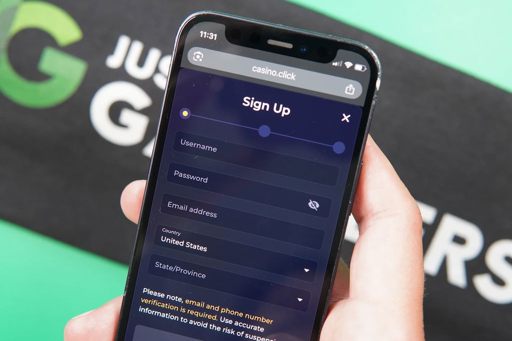 Patrik Lidin holding an iPhone with the Casino Click casino registration page loaded on the webpage.