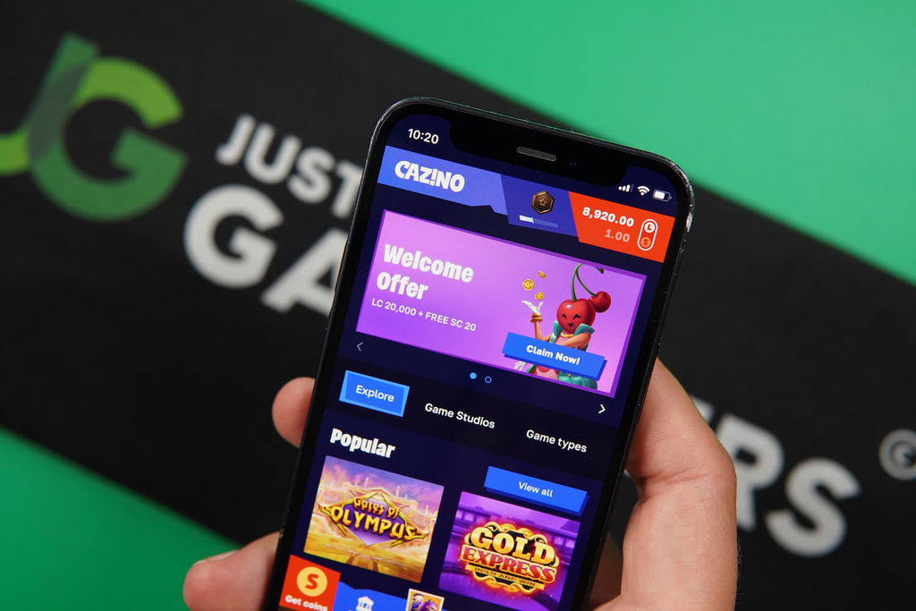 Patrik Lidin holding an iPhone with the Cazino casino landing page loaded on the webpage.