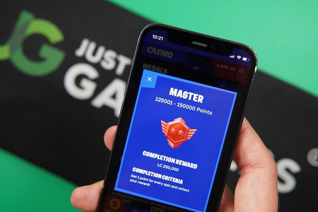 Patrik Lidin holding an iPhone with the Cazino casino loyalty program page loaded on the webpage.