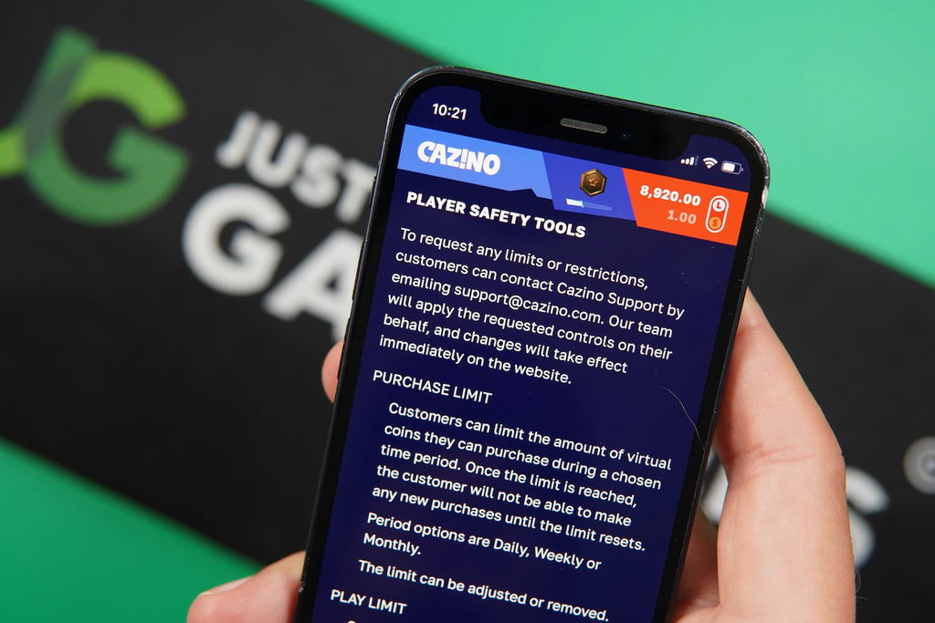 Patrik Lidin holding an iPhone with the Cazino casino responsible gaming page loaded on the webpage.