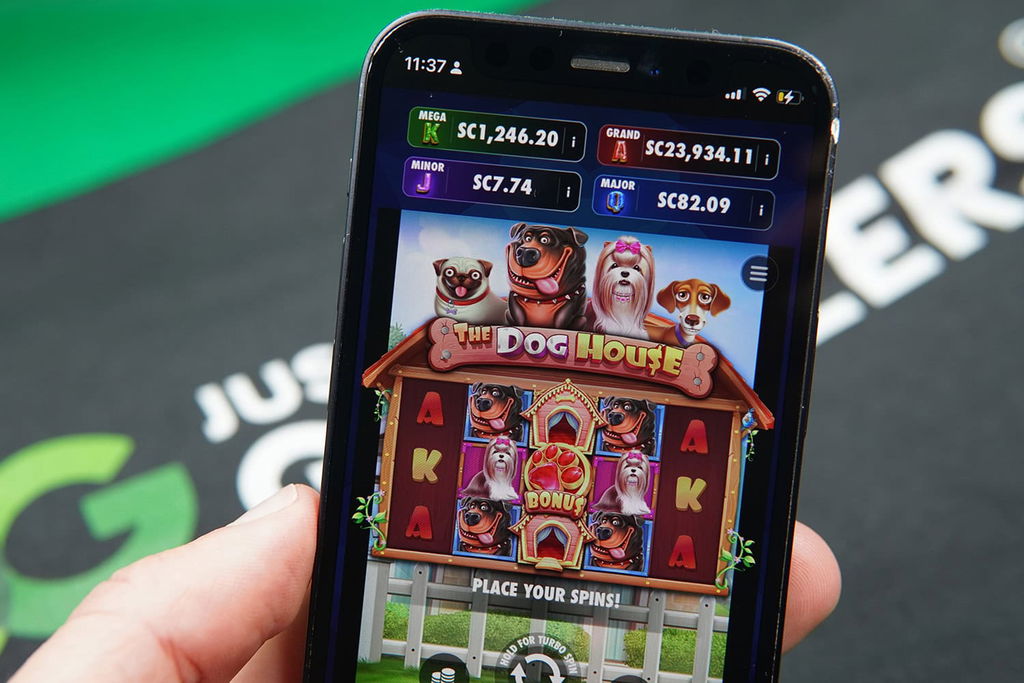 Patrik Lidin holding an iPhone with Chanced casino game The Dog House showing.