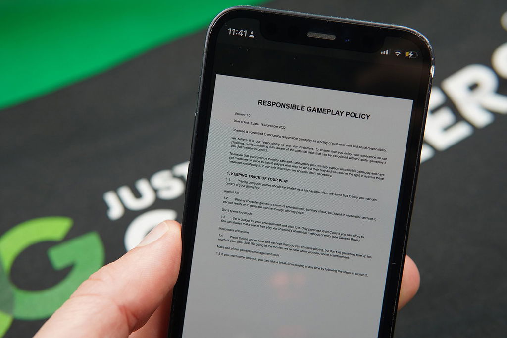 Patrik Lidin holding an iPhone with the Chanced responsible gambling page showing.