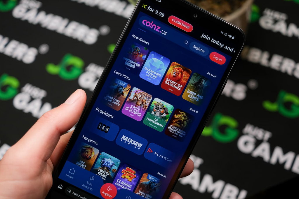Angela Zillich holding an Android Phone with Coinz.us casino games page loaded on the webpage.