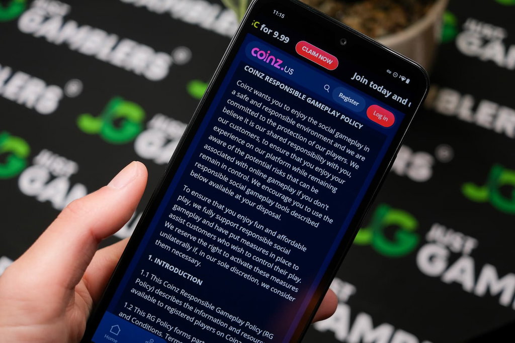 Angela Zillich holding an Android Phone with Coinz.us casino Responsible Play page loaded on the webpage.