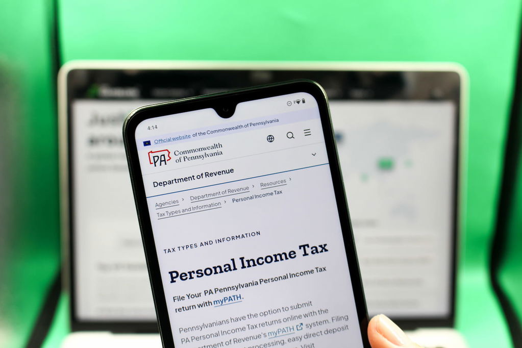 Photo of Angela Zillich holding an iPhone with Common Wealth of PA tax instructions booklet