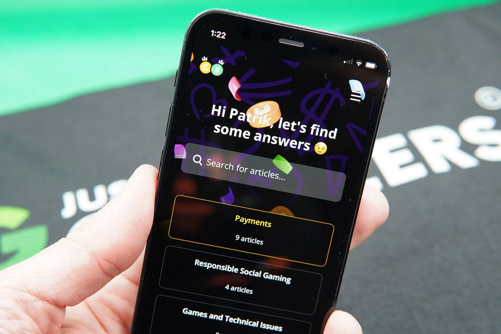 Patrik Lidin holding an iPhone while using the Crown Coins Casino customer support.