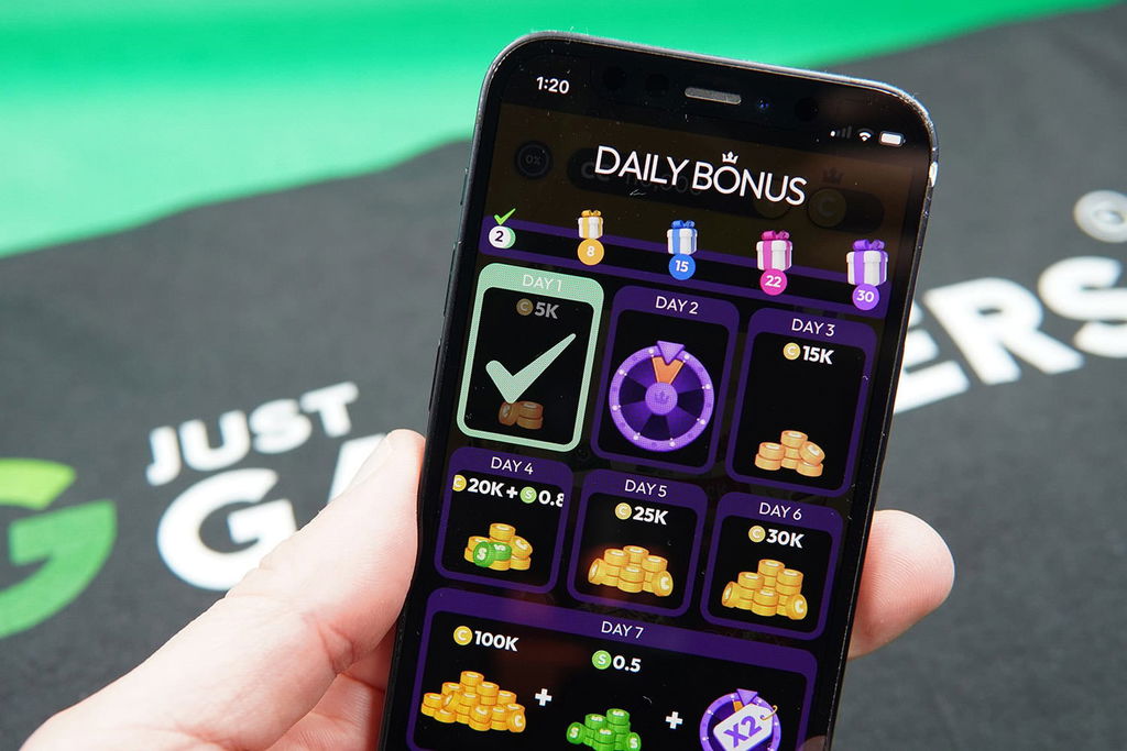 Patrik Lidin holding an iPhone with the Crown Coins rewards page loaded on the webpage.