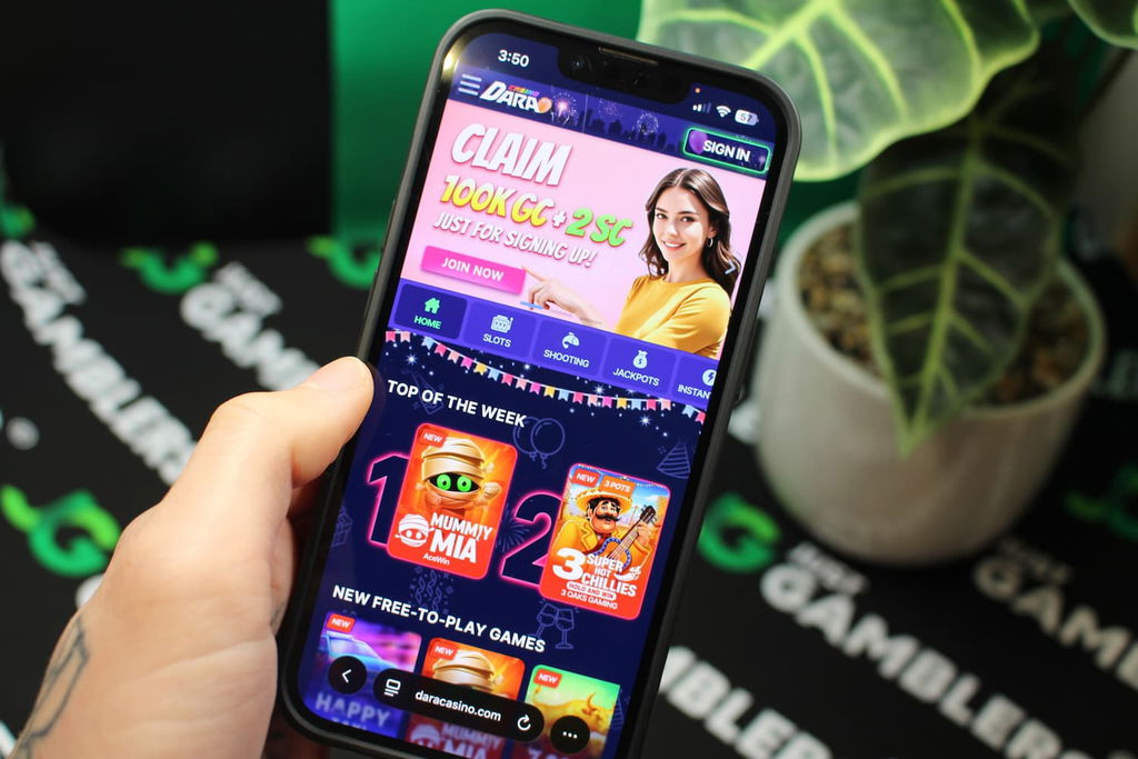 Angela Zillich holding an iPhone with the Dara casino landing page loaded on the webpage.