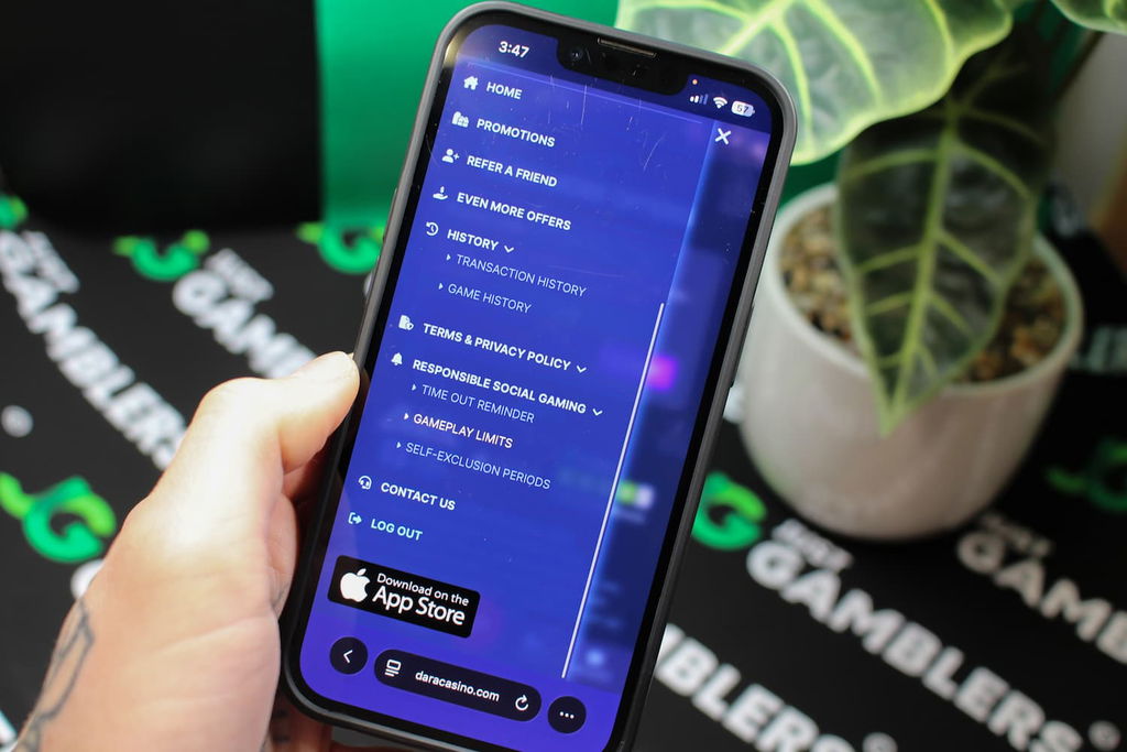 Angela Zillich holding an iPhone with the Dara casino menu page loaded on the webpage.