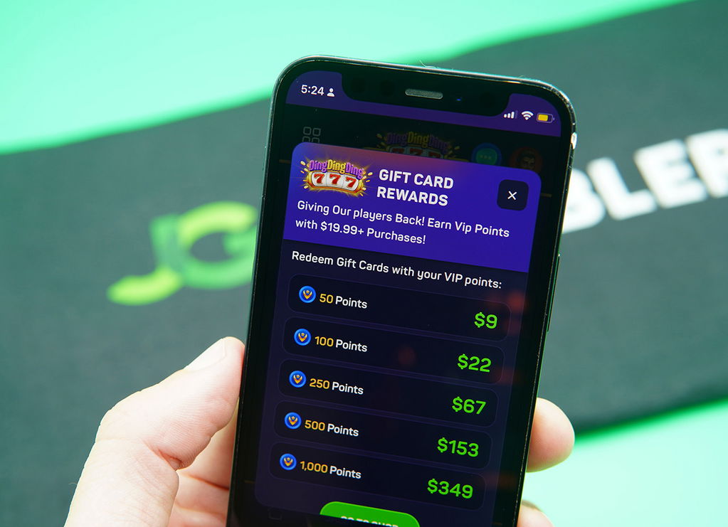 Patrik Lidin holding an iPhone with the DingDingDing gift card redemptions loaded on the webpage.