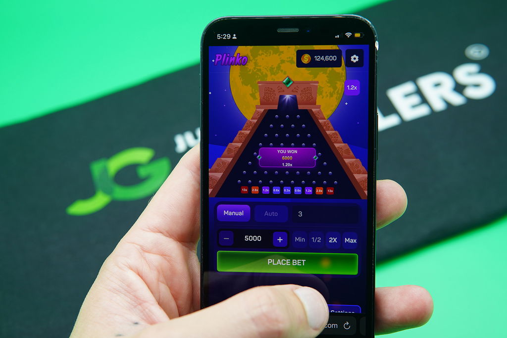 Patrik Lidin holding an iPhone with DingDingDing casino game Plinko showing.