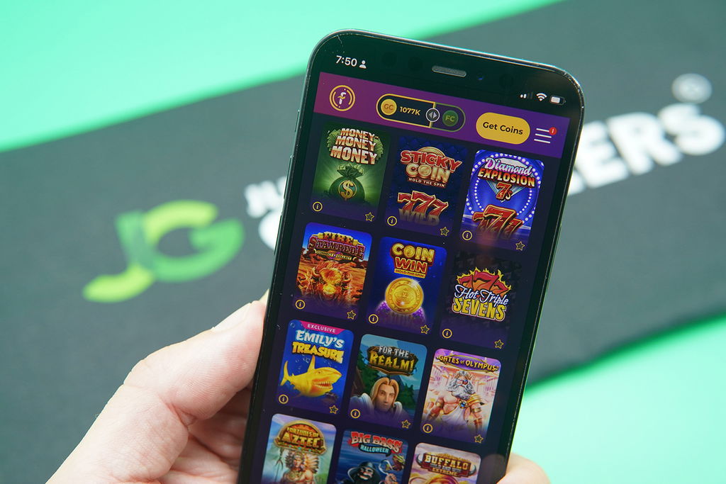 Patrik Lidin holding an iPhone with Fortune Coins game library showing.