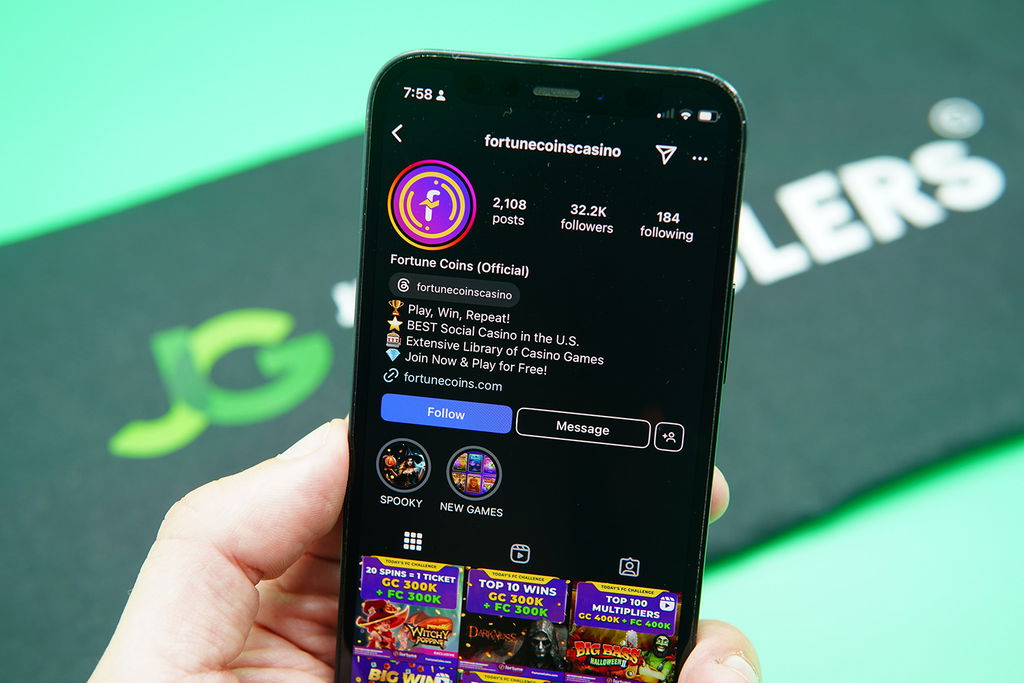 Patrik Lidin holding an iPhone with the Fortune Coins Instagram account.