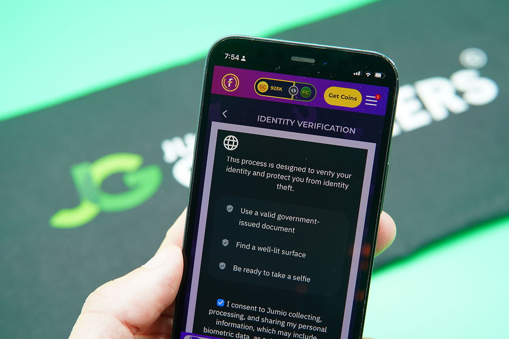 Patrik Lidin holding an iPhone showing the Fortune Coins KYC process.