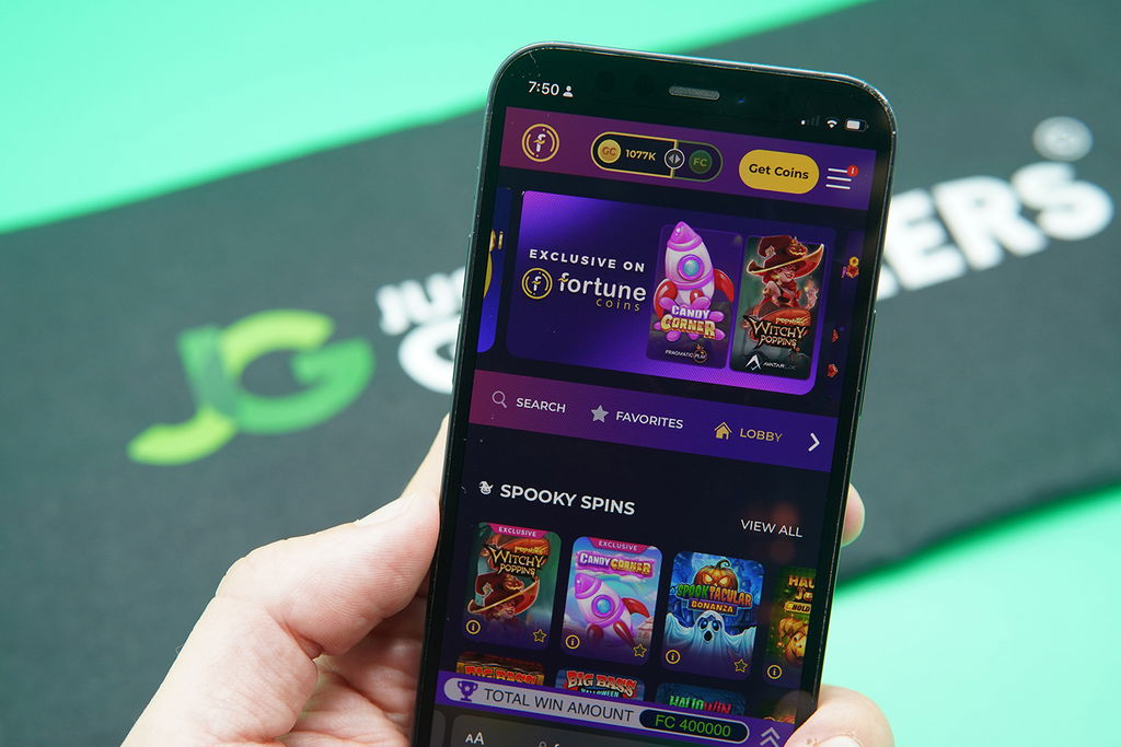 Photo of Patrik Lidin holding an iPhone to show how the Fortune Coins casino looks.