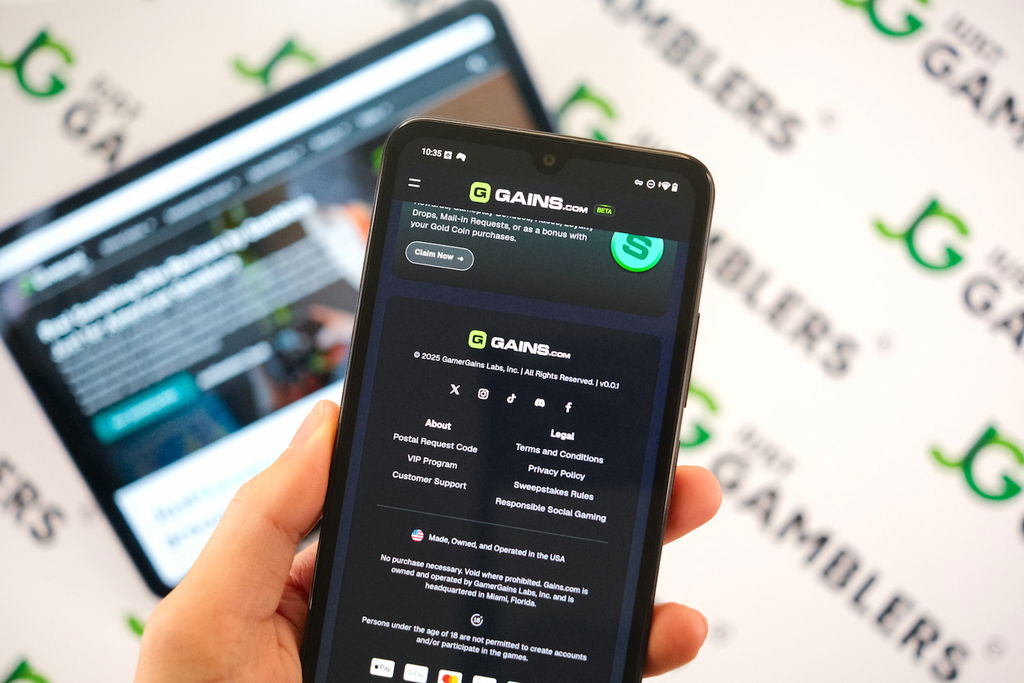 Angela Zillich holding an Android Phone with the Gains casino footer page loaded on the webpage.