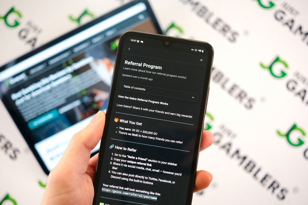 Angela Zillich holding an Android Phone with the Gains casino Referral Program page loaded on the webpage.