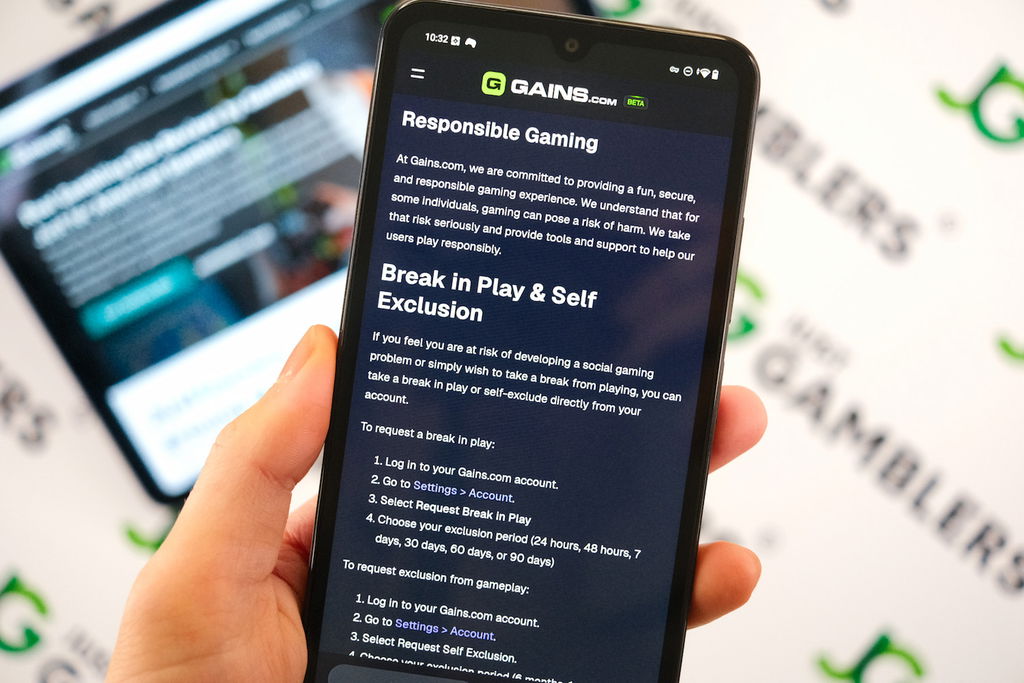 Angela Zillich holding an Android Phone with the Gains casino Responsible Gaming page loaded on the webpage.
