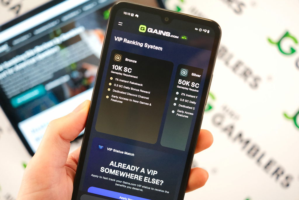 Angela Zillich holding an Android Phone with the Gains casino VIP Program page loaded on the webpage.
