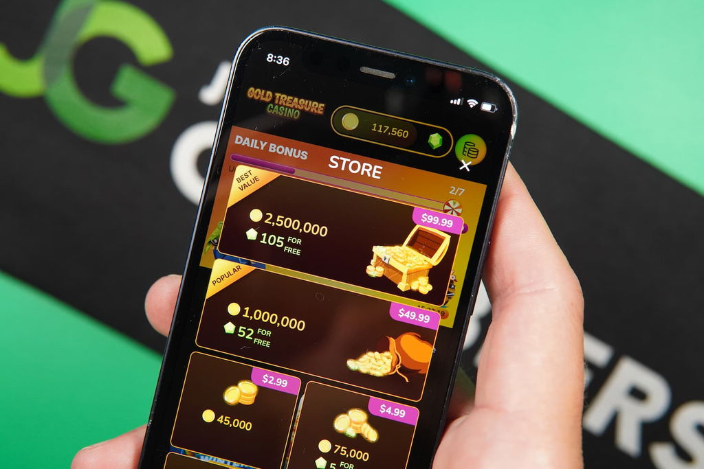 Patrik Lidin holding an iPhone with the Gold Treasure casino Purchases page loaded on the webpage.