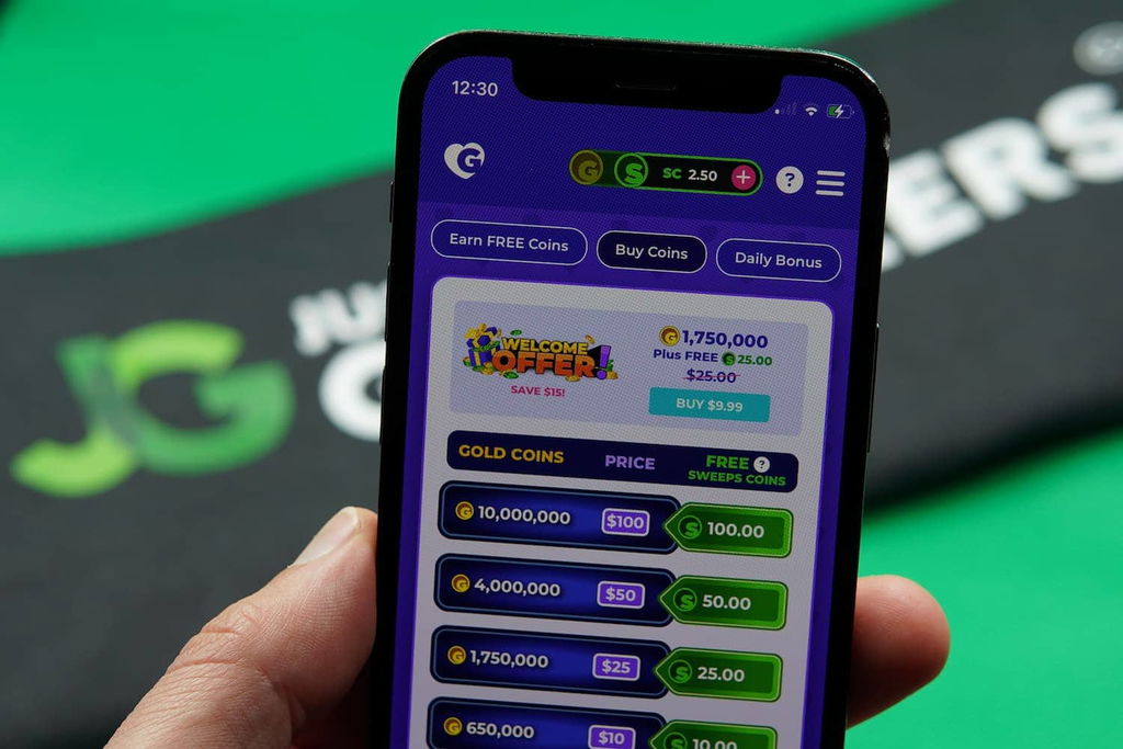 Patrik Lidin holding an iPhone with the Golden Hearts Games casino purchase page loaded on the webpage.