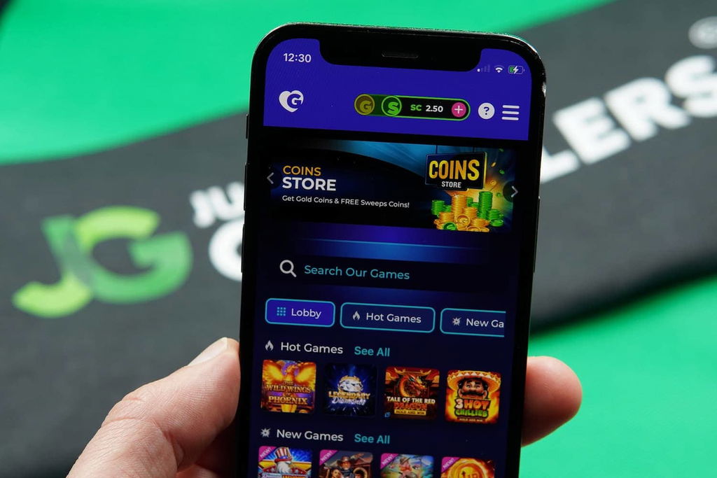 Patrik Lidin holding an iPhone with the Golden Hearts Games casino loading page loaded on the webpage.
