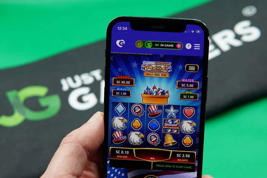 Patrik Lidin holding an iPhone with the Golden Hearts Games casino mobile in game page loaded on the webpage.