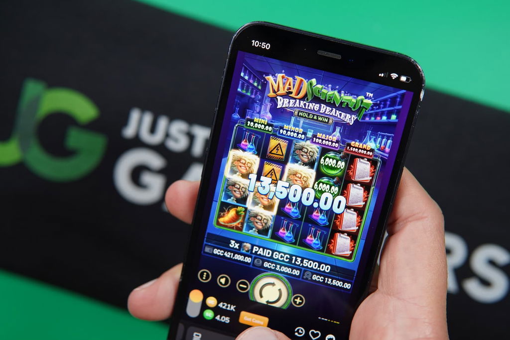 Patrik Lidin holding an iPhone with the GoldNLuck casino in-game mobile page loaded on the webpage.