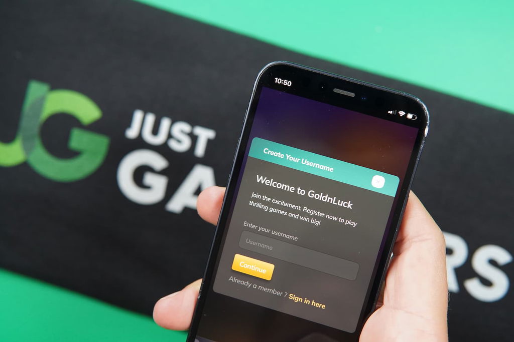 Patrik Lidin holding an iPhone with the GoldNLuck casino registration page loaded on the webpage.