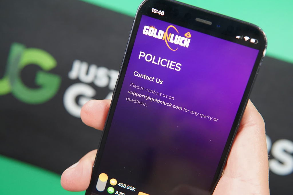 Patrik Lidin holding an iPhone with the GoldNLuck casino support page loaded on the webpage.