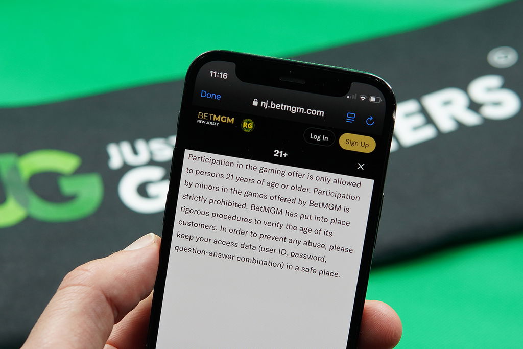 Photo of Patrik Lidin holding the BetMGM online casino showing the legal age